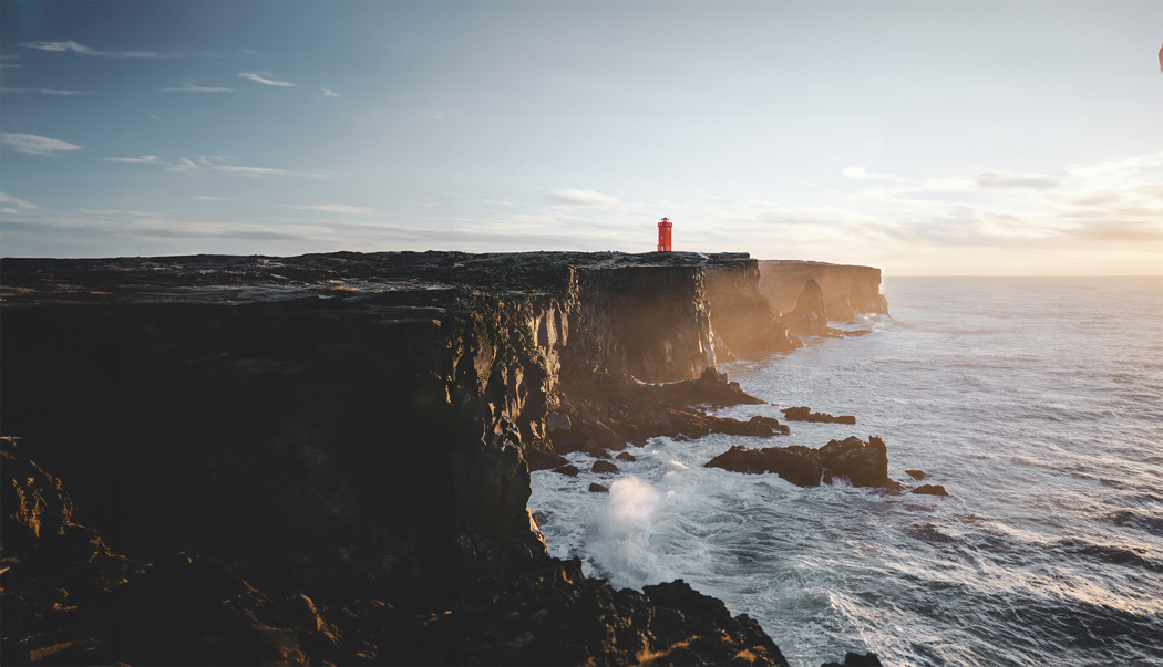 A red lighthouse on a cliff