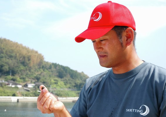 Fish farmer with feed pellet